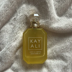 Kayali Lemon Sugar 14 Parfym - Kayali Capri In A Bottle Lemon Sugar | 14 är en parfym med fräsch och energisk vibe. Perfekt för dig som vill sticka ut med en modern och trendig doft. Snygg flaska som drar blickarna till sig.
