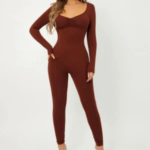 Brun långärmad jumpsuit  XS - Säljer en otroligt snygg jumpsuit i nyskick, använd endast 1 gång! Den har långa ärmar och en scoop neck som ger en elegant look. Jumpsuiten sitter fint på kroppen och formar figuren på ett fantastiskt sätt, med en scrunched detalj mellan brösten. Storlek XS. Perfekt för både fest och vardag!  Vänligen läs min bio innan du gör ett köp; där hittar du bland annat information om leveransprocessen med mera 😊  #jumpsuit #brun #fin