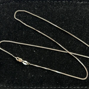 Tunt silverhalsband i äkta silver 925 - Säljer ett stilrent och tunt halsband i äkta silver med klassisk kedja och smidig karbinhake. Perfekt att bära som det är eller kombinera med ett hängsmycke. Enkelt och tidlöst smycke som passar till många olika stilar. 45cm