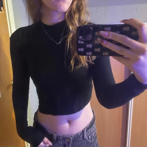 Svart fin topp med öppen rygg - Super fin topp som enligt mig man kan bära på två sätt! Man kan antingen ha den som en öppen rygg eller som en ur ringad framsida! Vet inte vart den är från eller vilken storlek men jag bär s-xs! 