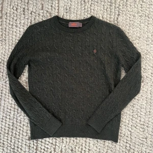 Mörkgrön Morris tröja - Mörkgrön stickad Morris-tröja, storlek S men krympt i tvätt – motsvarar mer en XS/XXS. Klassisk modell i fint skick, perfekt för höst säsongen. OBS tröjan ser mer grå ut i bilderna pga ljuset!