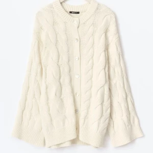 Vit kabelstickad kofta från Gina Tricot - Säljer en vit kabelstickad kofta från Gina Tricot med rund hals och knappar framtill. Koftan har breda ribbade muddar och ett chunky stickat mönster som ger en mysig vibe. (Säljer även den rosa och marinblå)