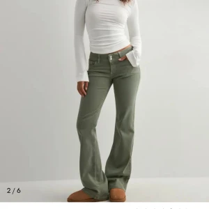 Olivgröna bootcut jeans från Nelly - Snygga olivgröna jeans från Nelly med bootcut-ben och klassisk femficksdesign. Byxorna har låg midja. Säljer då dom inte passade endast provade,prislappen sitter kvar!