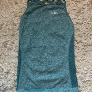 Turkos träningstopp från ICANIWILL XS - Säljer en turkos linnetopp från ICANIWILL i storlek XS. Toppen har snygga detaljer med öppning och korsade band i ryggen samt små hål längs sidorna. Perfekt för träning och tillverkad i ett stretchigt syntetmaterial. Knappt använd!! Pris diskuteras vid snabb affär 💕💕