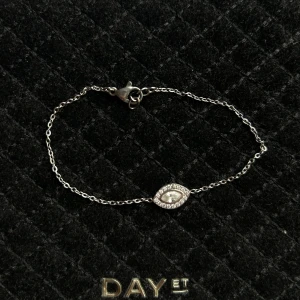 Rostfritt stål armband med diamant detalj - Stilrent silverfärgat armband från raglady by tara med tunn kedja och en glittrig, ögonformad detalj i mitten. Dekorerad med små gnistrande stenar som ger en lyxig känsla. Perfekt för dig som gillar diskreta men snygga accessoarer.