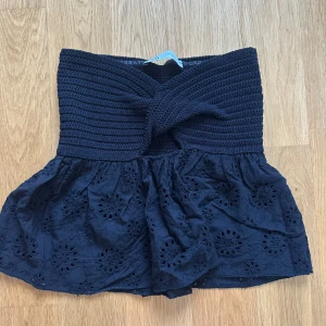 Svart söt topp från Zara med broderi - Supersöt svart topp från Zara med virkad midja och twistdetalj framtill. Kjolen har broderade blommor och volangkant nertill💓