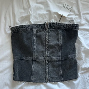 Svart jeans tubtopp från Zara - Supersnygg svart tubtopp i jeans från Zara som aldrig varit använd. Toppen har dragkedja framtill och smockad baksida för extra passform. Perfekt inför fester eller nu inför hösten💞🍁