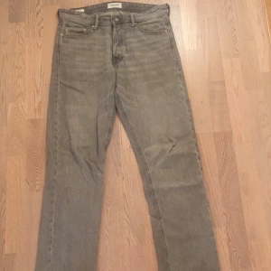 Grå loose fit jeans från Jack & Jones - Säljer ett par grå jeans från Jack & Jones i modellen Loose/Chris. Jeansen har en loose passform, raka ben och klassisk femficksdesign. Tillverkade i jeansmaterial och perfekta för dig som gillar en avslappnad stil.
