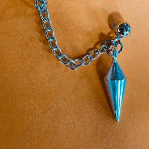 By prisförslag- 1 st Silvrigt dubbel-örhänge med kedja och konhänge - Coolt örhänge i silverfärg med en chunky kedja och ett konformat hänge. Fästs med en kula som har en snygg  detalj. Perfekt för dig som gillar edgy och unik stil.