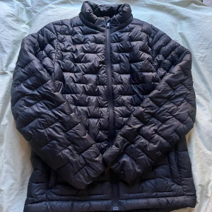 Svart pufferjacka från Everest - Svart pufferjacka från Everest med quiltad design och hel dragkedja framtill. Använd ett tag men lika fin som förut.