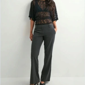 Mörkgrå kostymbyxor low waist - Snygga mörkgrå kostymbyxor med klassisk Flare -passform och low waist. Byxorna har raka ben och diskreta fickor framtill. Perfekta för en stilren och trendig look. Materialet känns mjukt och följsamt, vilket gör dem bekväma att bära hela dagen. Aldrig använda men utan prislapp. 