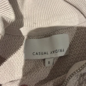 Beige half zip-tröja från Casual Friday - Säljer en stilren beige tröja från Casual Friday i storlek S. Tröjan har en snygg half zip-dragkedja med ring och ribbad krage. Materialet är strukturerat och känns mjukt mot huden. Perfekt för dig som gillar en clean och modern look. ( ny pris 499kr )