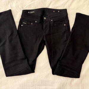 Svarta G-Star Midge bootcut jeans - Svarta jeans från G-Star, modell Midge, med klassisk femficksdesign och snygga silvriga nitar. Jeansen har bootcut-ben och normal passform. Perfekta för dig som gillar en stilren look. St 28x32 Köpta för 1200