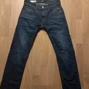 Mörkblå Replay jeans Rocco 29/32 - Snygga mörkblå jeans från Replay, modell Rocco med comfort fit. Klassisk femficksdesign och raka ben. Jeansen är tillverkade i slitstarkt denim och passar perfekt till en avslappnad stil.