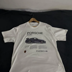 Porsche tshirt - Tja! Säljer min Porsche tshirt då den inte kommer till någon användning. Tröjan har aldrig använts utomhus utan bara testats så den är helt ny. T-shirten har inga tecken på användning. Det finns ingen logga på baksidan utan bara framsidan. 