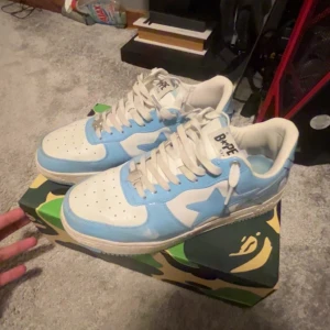 BAPE STA sneakers blå/vit - Den kommer med kvitto helt ny, insåg att dom var för stora för mig så jag behövde tyvärr sälja dom och pris är diskuterbarr Säljer ett par BAPE STA sneakers i fräsch blå . Kommer med original BAPE camo-låda. Du kan skriva vid minsta lilla fråga så svarar jag(:  (Bara används för att känna om allt sitter bra)