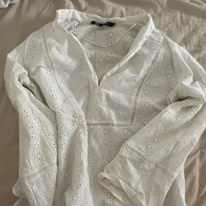 Jättefin vit blommig typ av skjorta - Jättefin och oanvänd skjorta som har bara blivit använd fåtals gånger. Väldigt vacker att ha till stranden med bikini under och matcha det men shorts. 