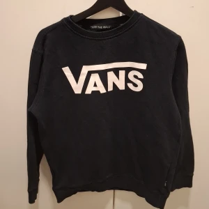 Svart sweatshirt från Vans i bomull L storlek för barn - Svart sweatshirt från Vans med stor vit logga framtill. Tröjan har rund halsringning, långa ärmar och är tillverkad i 100% bomull. Perfekt för en avslappnad streetstyle-look.