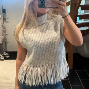 Grå stickad väst med fransar - Sååå cool stickad väst med fransar, använd 2 gånger 