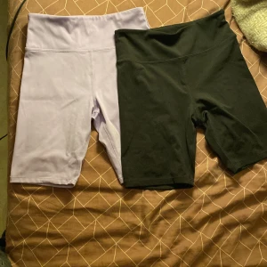 Två par cykelshorts från H&M Move - Säljer två par cykelshorts från H&M Move i storlek 146/152. Ett par är ljuslila och det andra är svarta. Båda har hög midja och är tillverkade i stretchigt syntetmaterial, perfekta för träning eller chill. Snygg och enkel design som är lätt att matcha.