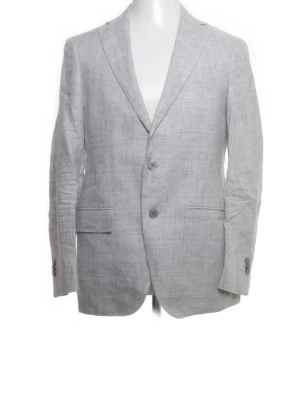 Ljusgrå linnekavaj från Boggi Milano - Snygg ljusgrå kavaj från Boggi Milano i 100% linne med slim fit-passning. Klassisk design med två knappar framtill, fickor med lock och slät rygg. Perfekt för dig som vill ha en stilren och fräsch look till våren eller sommaren.