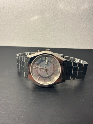 Vintage klocka  - silverfärgad armbandsklocka från Citco med automatisk urverk och dag/datumvisning. 36mm. Den behöver reparation ( det kostar runt 250 - 300kr )