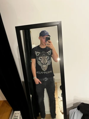 Philipp Plein t-shirt - Cool svart t-shirt från Philipp Plein med ett stort vargmotiv framtill och logotyp under. T-shirten har korta ärmar och en klassisk rund hals. Materialet känns mjukt och bekvämt, perfekt för dig som gillar statement-plagg.