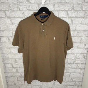 Ralph Lauren piké  - Ralph Lauren piké i klassisk modell och snygg brun nyans. Tidlös och lättburen tröja som passar perfekt till vardag och sommarbruk. I mycket bra skick och väl omhändertagen. Hör av dig vid intresse 🙌