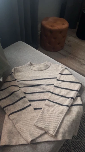 Beige randig stickad tröja Vero Moda - Supermysig stickad tröja från Vero Moda i beige med svarta horisontella ränder. Tröjan har rund hals, långa ärmar och breda ribbade muddar vid ärmslut och nederkant. Kan gå ner i pris vid snabb affär! Tröjan är i storlek S. Skriv gärna om du har någon fråga eller om du vill se mer bilder t.ex. tröjan på💕