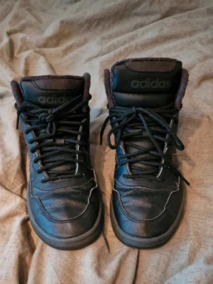 Svarta sneakers från Adidas - Välanvända men har fortfarande lite kvar att ge. Perfekt för växande fötter som inte kan ha skor länge än en säsong. De är noppriga och sulan har släppt lite vid tårna på högerfoten. Stl 39 1/3