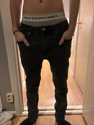 Svarta jeans  - Säljer ett par svarta jeans med klassisk femficksdesign. Jeansen har en avslappnad passform och raka ben, perfekta för en chill och streetinspirerad stil. Width: 30. Length: 32