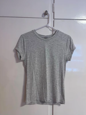 Soft touch T-shirt - En enkel och stilren ljusgrå t-shirt med rund hals och korta ärmar. Den är i soft touch.  Perfekt att matcha med jeans eller shorts för en avslappnad look. Tillverkad i mjuk bomull som känns skön mot huden.