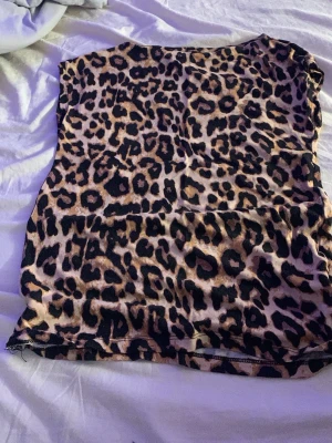 Leopardmönstrad ärmlös tröja - Snygg ärmlös topp med leopardmönster i bruna och svarta toner. Perfekt för dig som vill sticka ut och addera lite edge till din outfit. Toppens material känns mjukt och följsamt mot huden.🩷