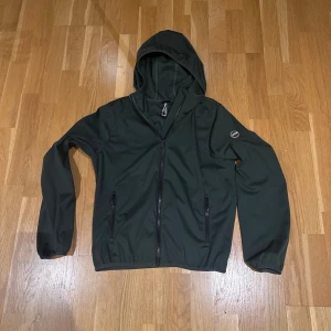 Mörkgrön colmar vindjacka - Stilren mörkgrön colmar vindjacka. Den är använd max 5 gånger och är i nyskick. 