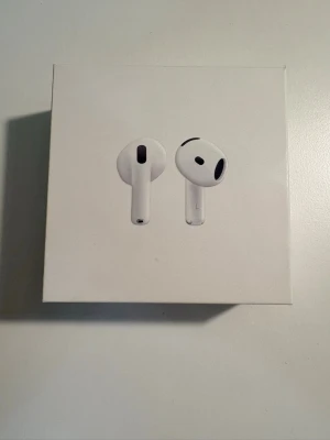 Apple AirPods trådlösa hörlurar - Säljer ett par vita Apple AirPods med laddningsetui. Snygg och stilren design i plast, perfekt för dig som vill ha smidiga och trådlösa hörlurar till mobilen. Laddningsetuiet är kompakt och lätt att ta med sig överallt.