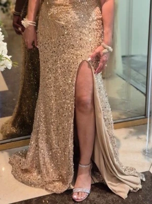 Champagnefärgad långklänning - Säljer denna som är använd vid ett tillfälle (4h). Säljer den i bra skick utan skador.