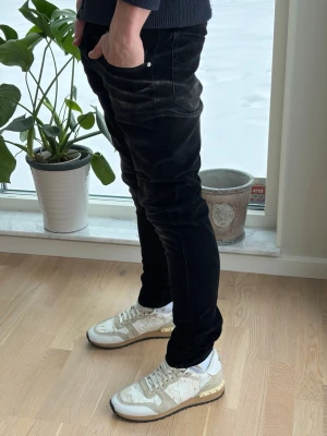 Svarta skinny jeans herr - Säljer ett par svarta skinny jeans med klassisk femficksmodell och smal passform. Jeansen har låg midja och är tillverkade i stretchigt bomullsmaterial för extra komfort. Perfekta för dig som gillar en tajt och modern look.