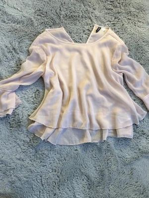 Rosa volang blus - En rosa blus med volanger nere och slutet av ärmarna. Den har en knapp att knäppa i nacken och är genomskinlig (se sista bilden). Storlek 42, men passar även mig som ca. 160.💗