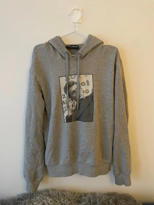 Grå hoodie james dean hoodie från Dolce & Gabbana - Grå hoodie från Dolce & Gabbana med ett svartvitt porträtt av james dean på framsidan. Storlek 52 som passar M/L, gott skick utan särksilt märkbar användning. Passformen är true to size. 