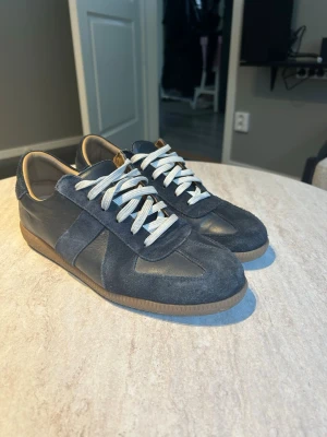 Mörkblå sneakers i mocka och skinn - Snygga mörkblå Gats med ovandel i både mocka och skinn, vita snören och brun sula. Hör av er vid frågor!!