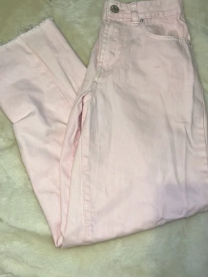 Ljusrosa straight jeans från Amisu - Säljer ett par ljusrosa straight jeans från Amisu i storlek 34. Klassisk femficksmodell med knapp och dragkedja framtill. Jeansen har en enkel och clean look, perfekta att styla med sneakers eller boots.