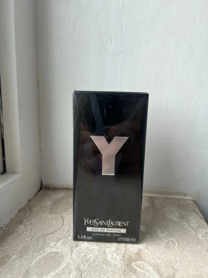 Yves Saint Laurent Y Eau de Parfum - Y Eau de Parfum från Yves Saint Laurent är en stilren parfym i svart, rektangulär flaska med en stor silverfärgad Y-logga på framsidan. Förpackningen rymmer 100 ml och har en lyxig och modern design som passar perfekt för dig som gillar exklusiva dofter.
