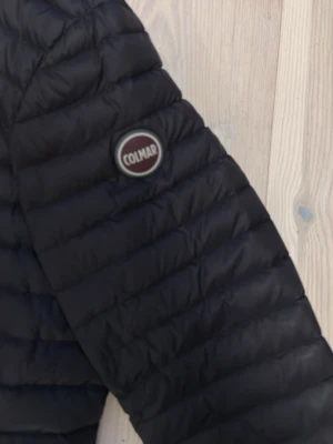 Svart dunjacka från Colmar 14Y - Säljer en svart dunjacka från Colmar i storlek 14Y (166cm)har krympt i tvätten så passar medr 160. Jackan har quiltad design, två dragkedjeförsedda fickor och Colmar-logga på ärmen. Perfekt för dig som vill ha en lätt och smidig jacka med snygg passform och skön vibe . Nypris 3499