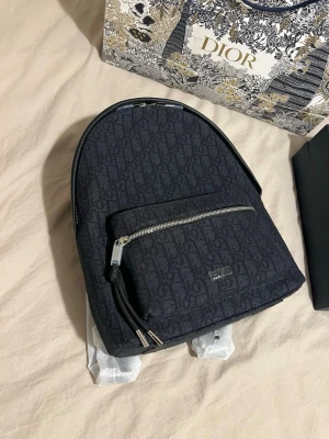 DlOR väska - Rider Backpack Black DlOR Oblique Jacquard. Du har chansen att slå till en diskret DlOR väska för endast 1000 kr. FAST PRIS! Dustbag och veriferingskort följer med. Snabb leverans  📦 Passa på!