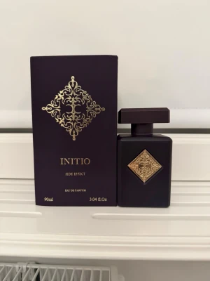 Initio Side Effect EdP 90ml - Initio Side Effect Eau de Parfum, 90ml. Tillverkad i Frankrike. Parfymen luktar vanilj, en svag doft av tobak och en väldigt god rom linnande doft, perfekt för de kuliga dagarna! Köptes på parfym .se. Ca 80-85 ml kvar.