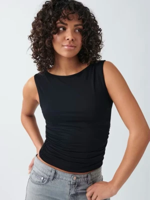 Svart ärmlös linnetopp - Snygg svart ärmlös linnetopp med rund halsringning och figurnära passform. Toppen har en enkel och stilren design som passar perfekt till jeans eller kjol. Tillverkad i ett mjukt och stretchigt material som sitter skönt mot kroppen. Knappast använd. Storlek xs och slutsåld.