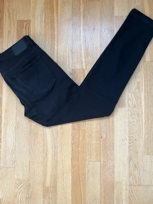 Svarta skinny jeans W32 L32 - Säljer ett par svarta skinny jeans från Indeero i storlek W32 L32. Jeansen har klassisk femficksdesign, bälteshällor och knappgylf. Snygg, enkel look som passar till allt och är tillverkade i stretchig bomullsblandning för extra komfort.
