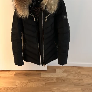 Hollies vinterjacka strl 35 - Snygg vinterjacka i bra skick. Varmt foder i dun  Äkta päls Storlek 36.  