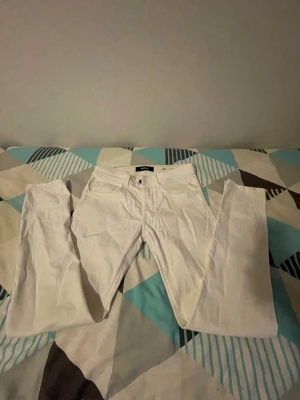 Vita Replay jeans, storlek 29/30 - Säljer ett par fräscha vita jeans från Replay i storlek 29/30. Klassisk femficksmodell med raka ben och normal passform. Snyggt blått Replay-märke baktill. Perfekta för dig som gillar stilrena och ljusa jeans. Använda ett par gånger. Pris kan diskuteras. 