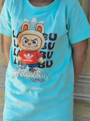 Turkos t-shirt med Adidas-tryck - Säljer en turkos t-shirt med stor, färgglad print framtill av en tecknad figur i röd Adidas-tröja och texten 'Adidas Originals'. T-shirten har rund hals och korta ärmar, perfekt för dig som gillar streetstyle och coola motiv.